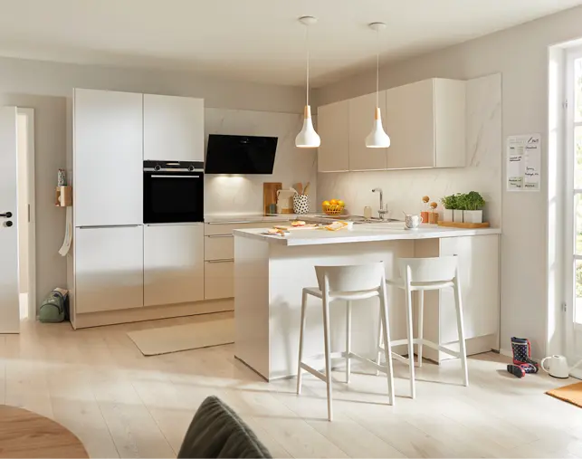 Helle Einbauküche in Weiß mit Kochinsel, Barhockern und integrierten Elektrogeräten. Minimalistisches Küchendesign mit Pendelleuchten, viel Stauraum und offener Raumgestaltung für modernes Wohnen und zeitgemäße Küchenplanung.